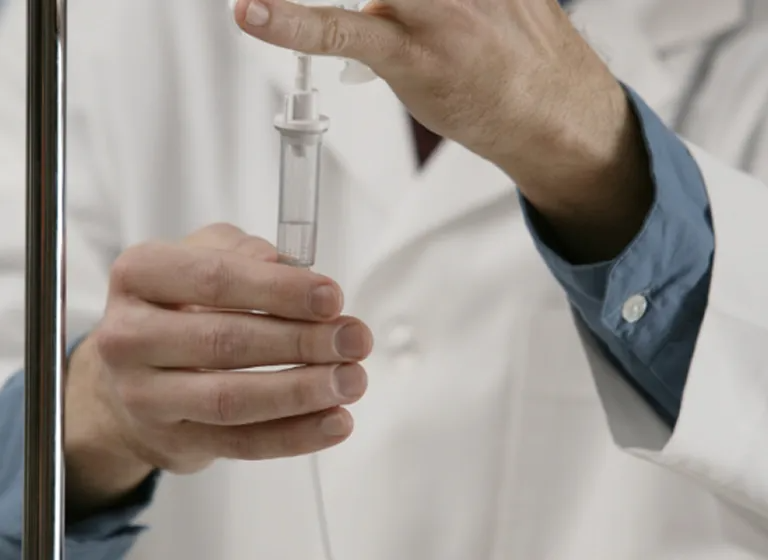 Healthcare professional preparing IV therapy for hydration and nutrient replenishment at Zēl Vitality wellness center.